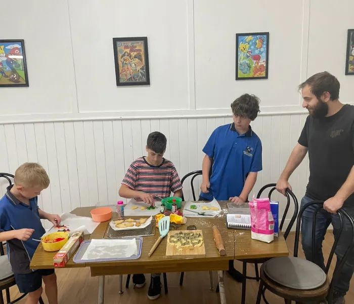 Group of young children baking with support worker