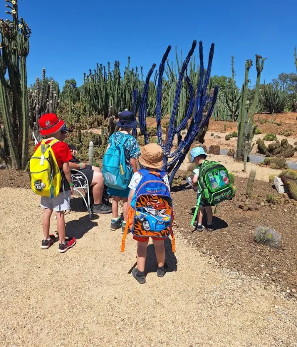 Group of young children outside looking at cactus garden