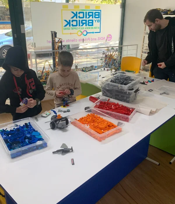 Two young kids playing with lego with support worker at Brick by Brick facility