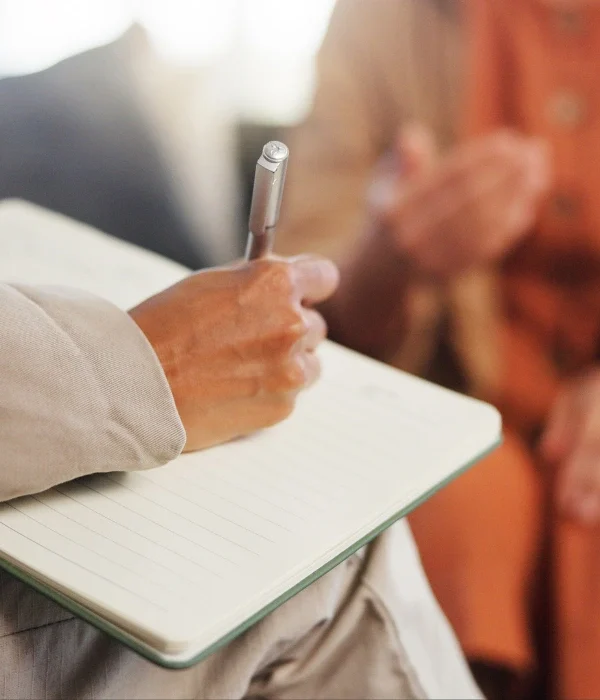 Close up of hand writing in notebook with pen